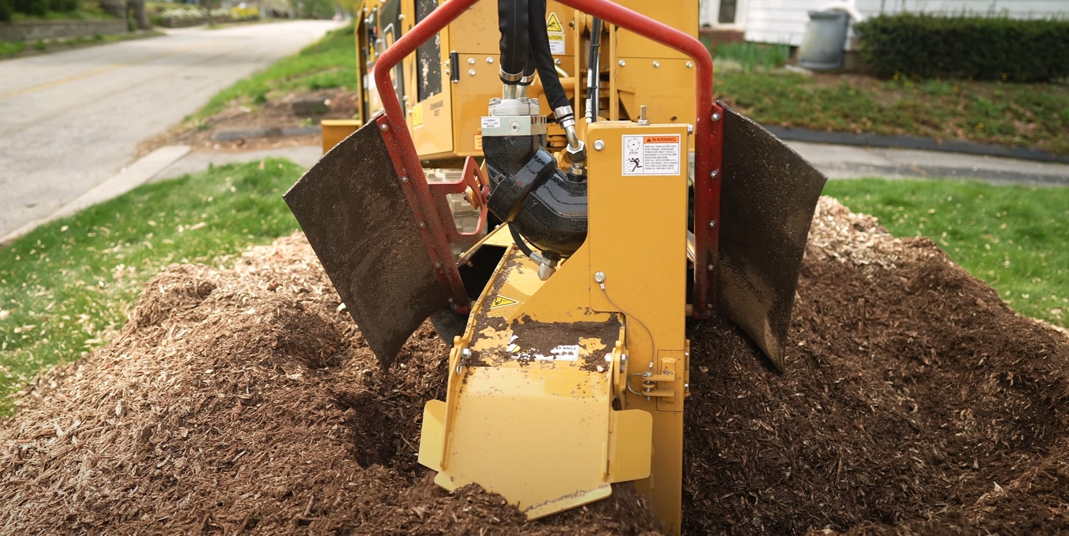 Industrial stump grinding equipment removing tree stump in Compton, CA residential yard